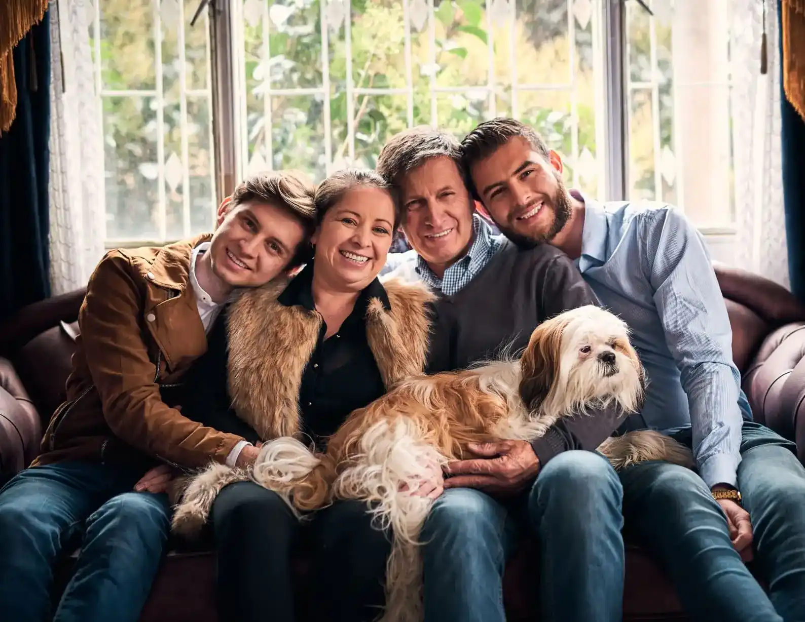 familia unida con su fiel amigo(un perro) sentados en un sofa, reflejan felicidad